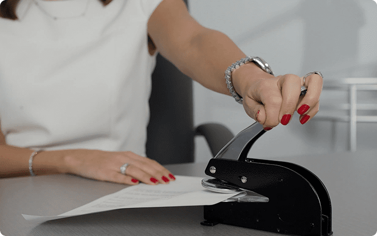 A woman is using a paper shredder